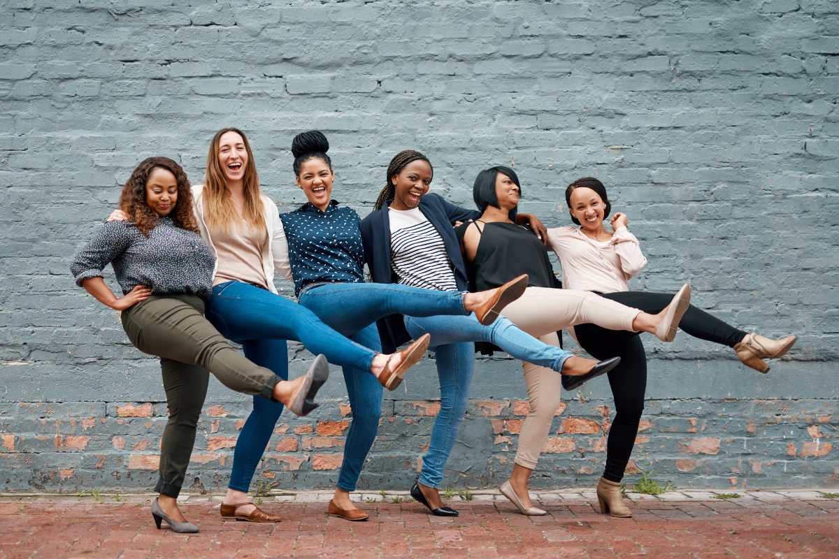 A group of diverse women smiling and celebrating, reflecting empowerment through free DIY credit repair.