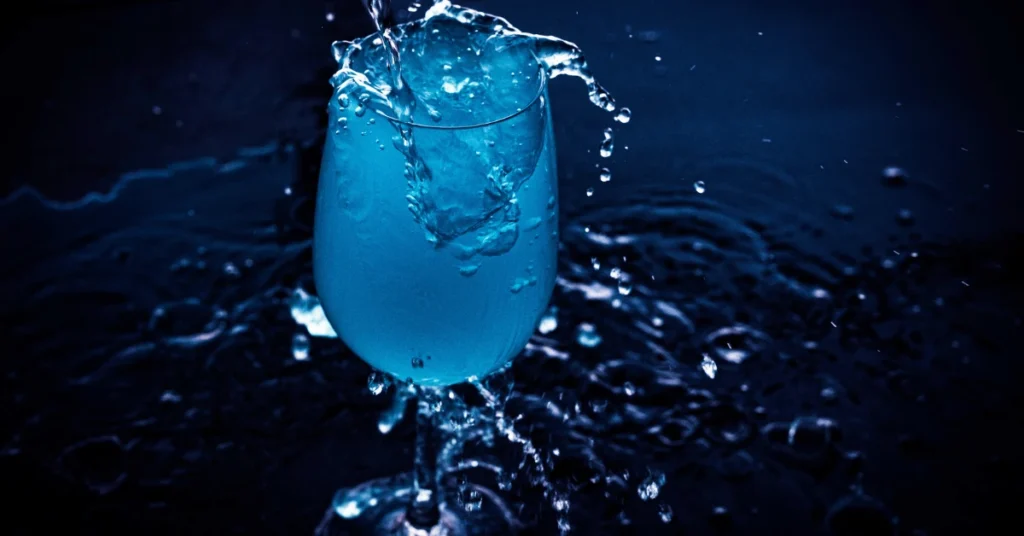Overflowing water glass symbolizing the self-full concept of giving to others from abundance.